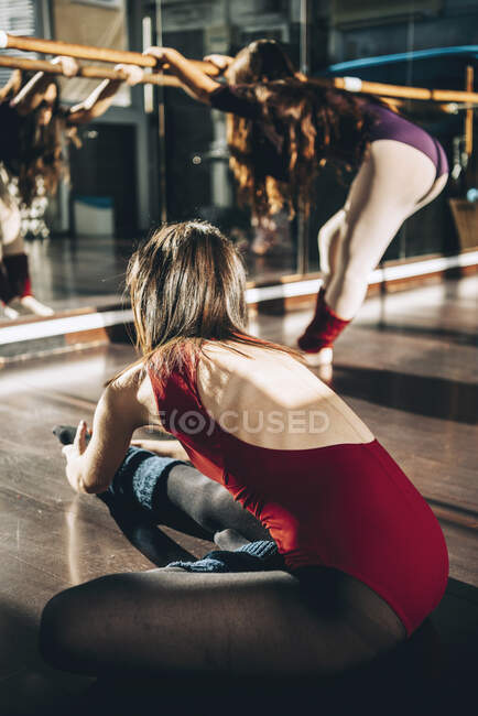 Young dancers training together in studio warming up and flexing in sunlight. — Stock Photo
