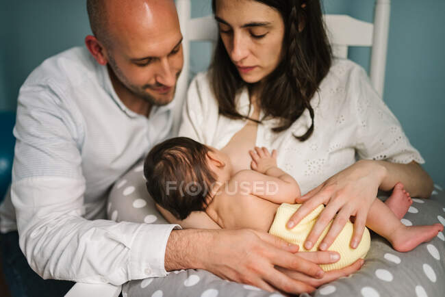 Happy parents feeding baby — Stock Photo