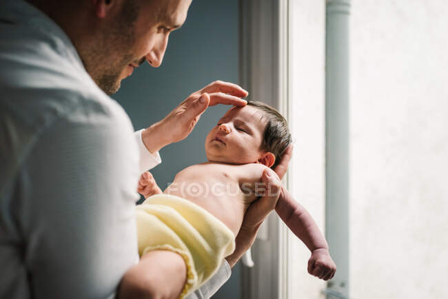 Padre sosteniendo a su pequeño bebé - foto de stock