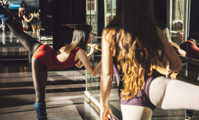 Young fit women training and dancing ballet with barre. — Stock Photo
