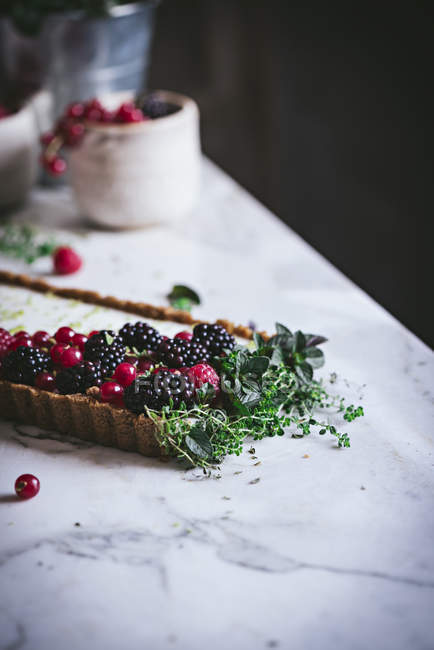 Лаймовый пирог со свежими ягодами на поверхности белого мрамора — стоковое фото