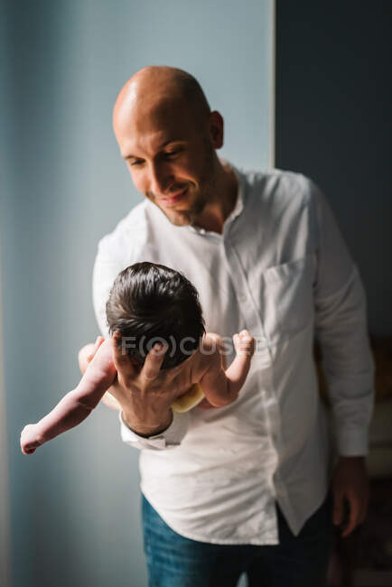 Padre sosteniendo a su pequeño bebé - foto de stock