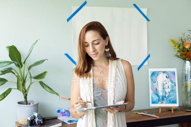 Latin artist painting with watercolor in her studio — Stock Photo