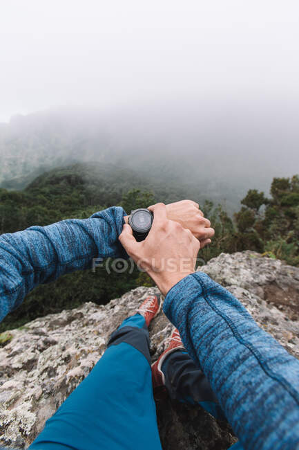 First person view of a crop hand of guy using a watch in the mountains — Stock Photo
