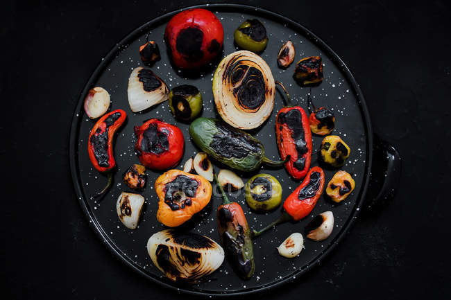 Delicious roasted vegetables on black tray — Stock Photo