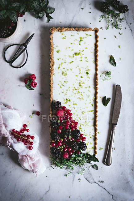 Лаймовый пирог со свежими ягодами на поверхности белого мрамора — стоковое фото