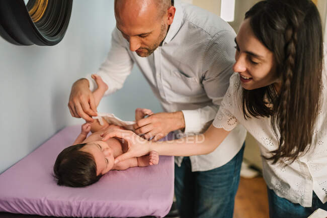 Parents changing diaper for baby — Stock Photo