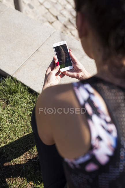 Primo piano della donna bruna seduta e controllare le statistiche dell'app di formazione — Foto stock