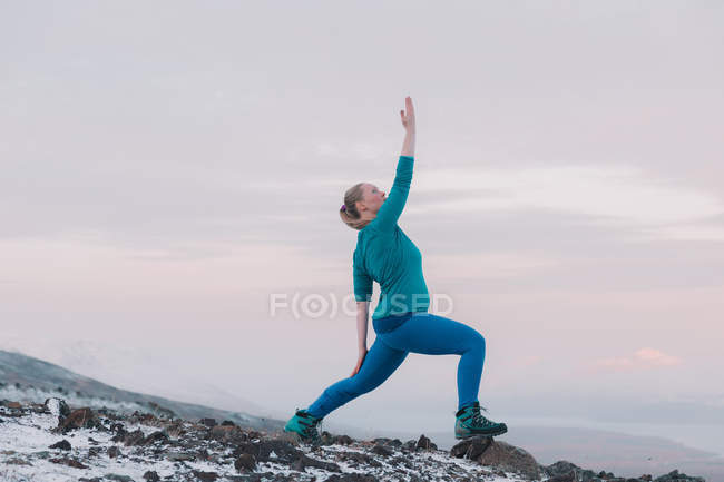 Mujer rubia haciendo ejercicio en la montaña nevada en la naturaleza - foto de stock