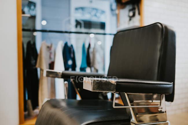 Cadeira de couro moderno na barbearia no fundo borrado — Fotografia de Stock