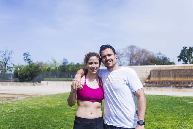 Портрет пара в спортивному одязі, що позує в парку в сонячний день — стокове фото