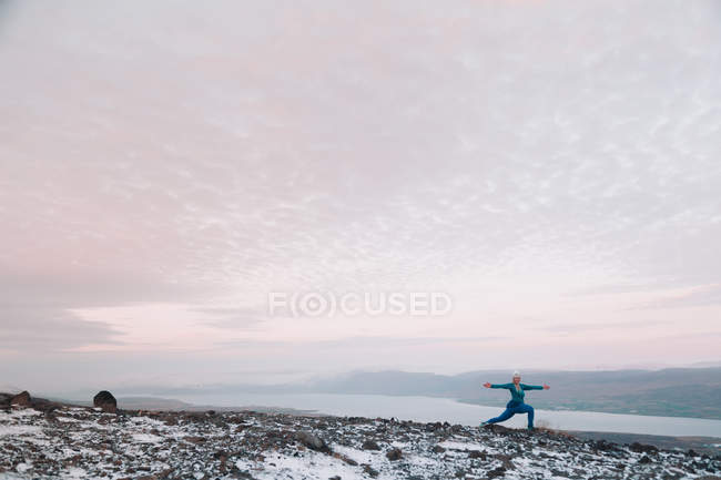 Blond woman exercising on snowy shore in nature — Stock Photo