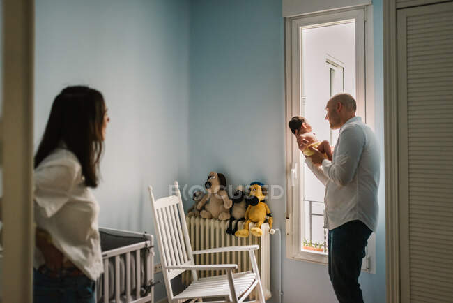 Pais conversando com o bebê no berçário — Fotografia de Stock