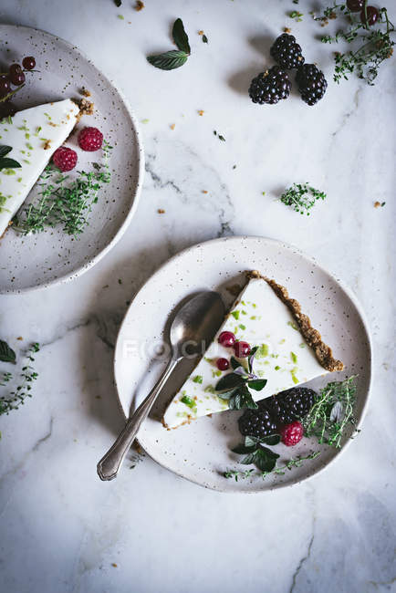 Piece of lime pie with fresh berries on plate on white marble surface — Stock Photo