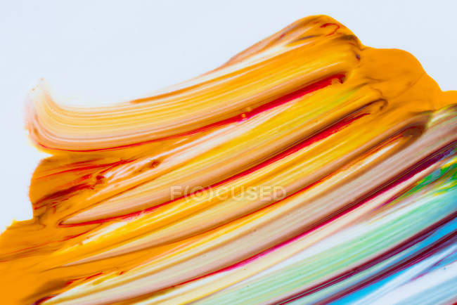 Pinceladas multicolores de colores acrílicos sobre lienzo blanco - foto de stock