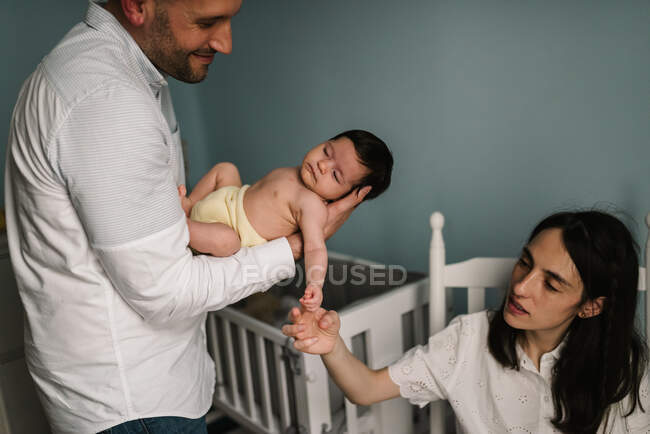 Pais segurando bebê no quarto — Fotografia de Stock