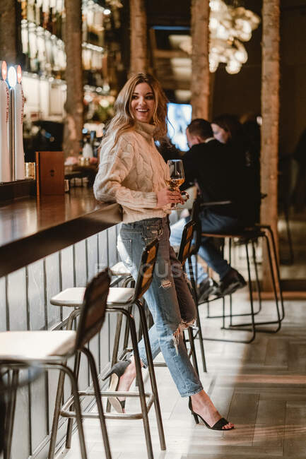 Стильная женщина пьет вино в баре — стоковое фото
