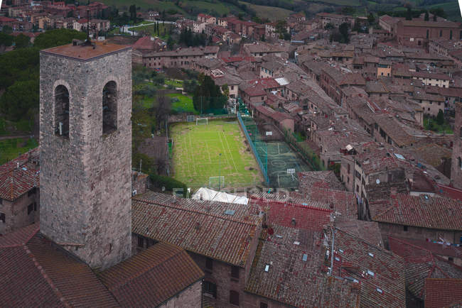 View of old stone buildings with football field, Italy — Stock Photo