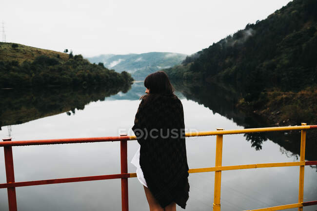 Donna in piedi cercando incredibile lago vicino alle montagne — Foto stock