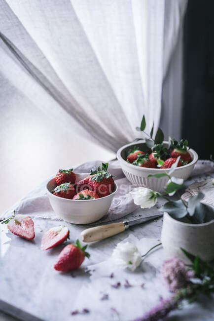 Полуниця і квіти на мармуровому столі — стокове фото