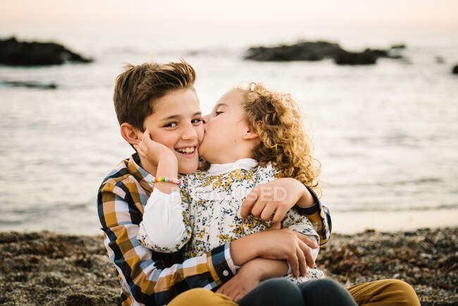 Cheerful and cute boy and girl smiling and hugging each other at the beach  — caucasian, happiness - Stock Photo | #266480456