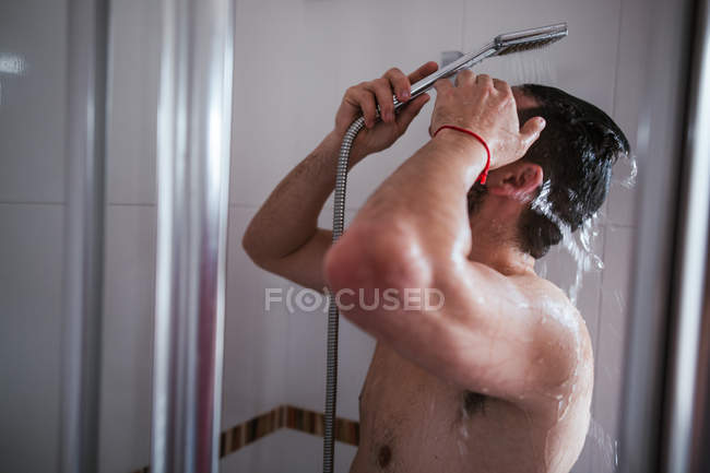 Shirtless unrecognizable man having shower in bathroom — Stock Photo