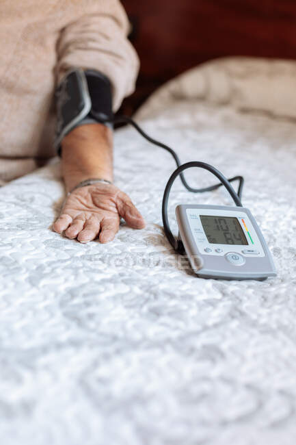 Elder man checking his arterial pressure with machine — Stock Photo