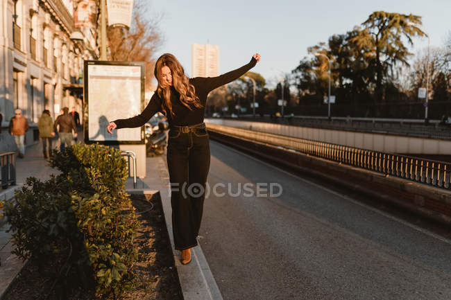 Стильна жінка балансує на тротуарі біля станції метро — стокове фото