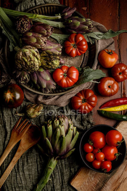 Conjunto de varias verduras frescas y servilletas de tela rústica en la mesa en la cocina - foto de stock