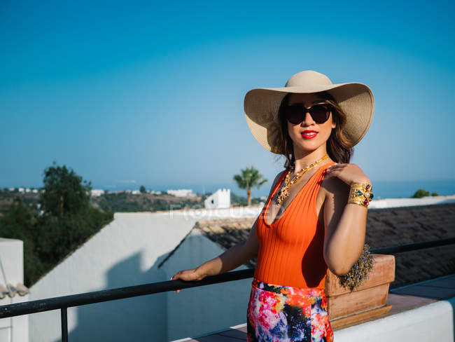Молода стильна жінка в панамському капелюсі і сонцезахисні окуляри позують в яскравий літній день — стокове фото