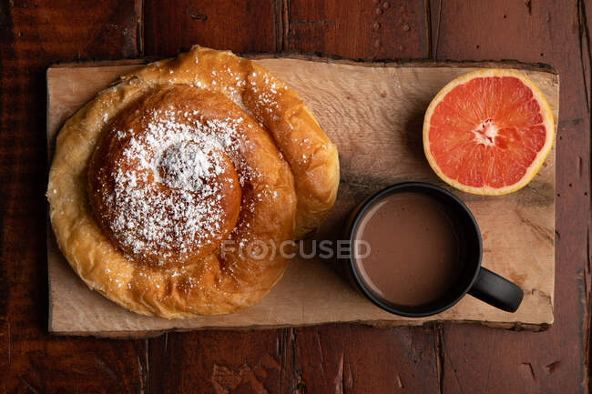 Bebida quente fresca e vários saborosos alimentos de pequeno-almoço colocados na mesa de madeira na parte da manhã — Fotografia de Stock