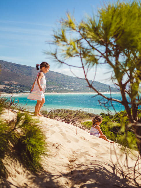 Meninas pequenas dando um passeio na praia em um dia ensolarado — Fotografia de Stock