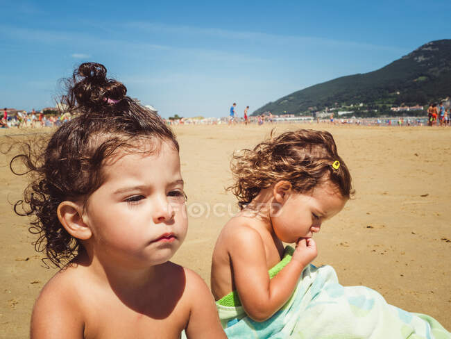 Portrait de petites filles se reposant à la plage par une journée ensoleillée — Photo de stock