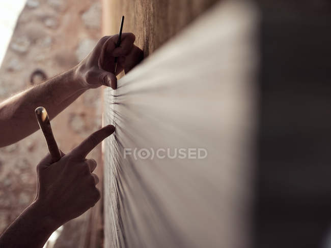 Руки анонімних чоловічого художника з інструментами малювання зворушливі полотно під час роботи в майстерні — стокове фото