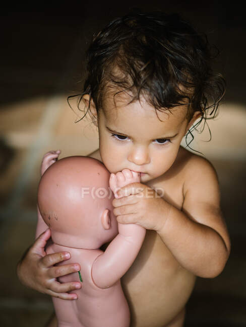 Menina pequena brincando com um bebê boneca — Fotografia de Stock