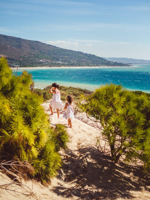 Kleine Mädchen spazieren an einem sonnigen Tag am Strand — Stockfoto