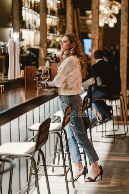 Stylish woman drinking wine in bar — Stock Photo