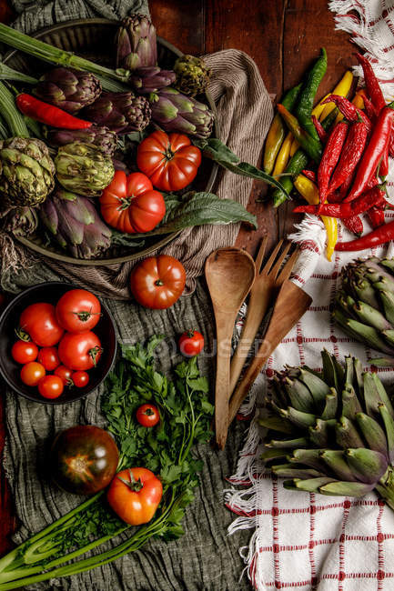 Набір різних свіжих овочів і серветок для тканини сільський на столі на кухні — стокове фото