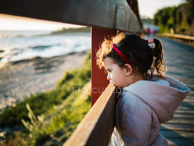 Vista lateral de una chica pensativa en la playa en invierno - foto de stock