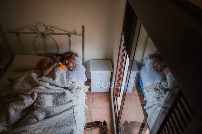 Embracing gay couple resting in bed in morning — Stock Photo