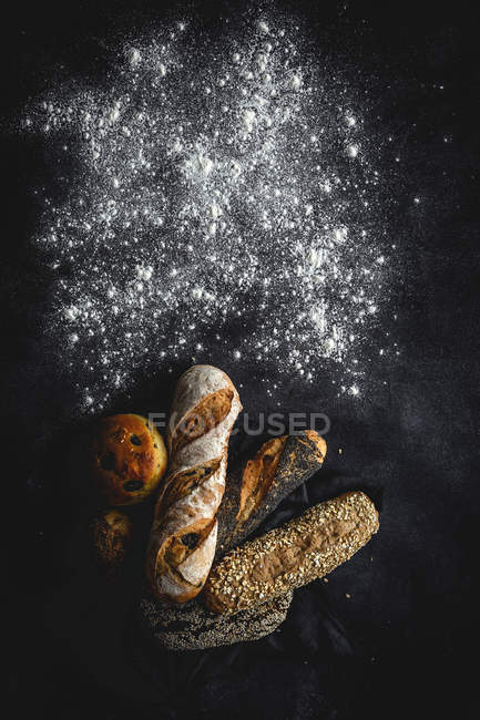 Ассортимент самодельных свежеиспеченных хлебов на черном фоне — стоковое фото