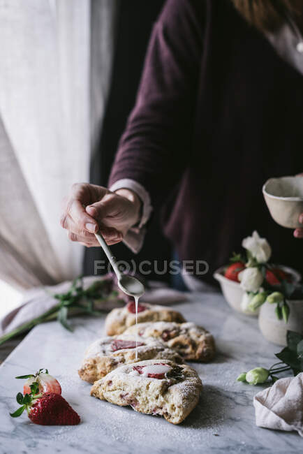 Crop person spilling sauce on scones — Stock Photo