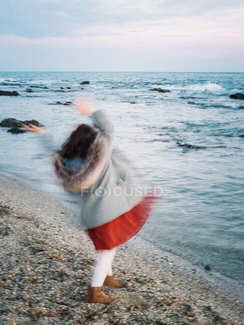 Anonymous little girl moving by the beach and looking at the sea on a winter day — Stock Photo