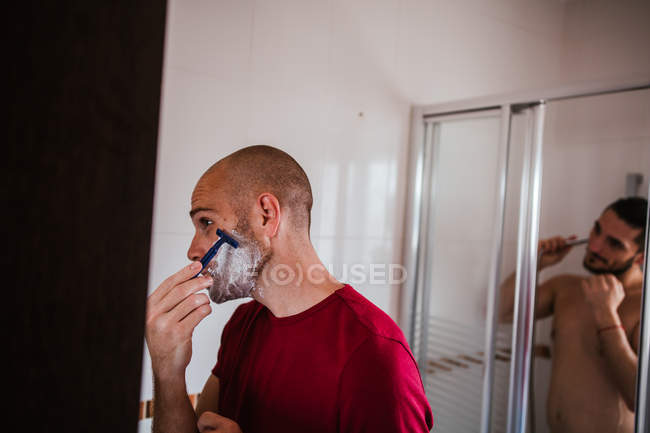 Гей пара принимает душ и бритье в ванной комнате вместе — стоковое фото