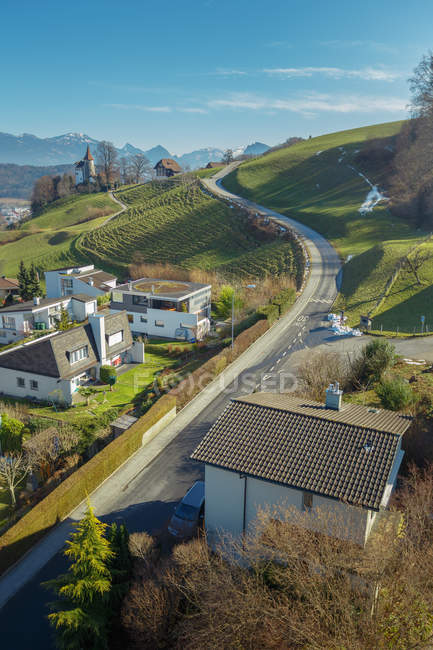 Paisagem pitoresca de cidade pequena e estrada no vale de montanhas verdes, Suíça — Fotografia de Stock
