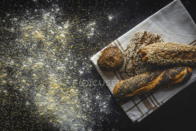 Sortimento de pães cozidos na hora caseiros sobre fundo preto — Fotografia de Stock