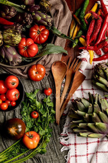 Conjunto de vários legumes frescos e guardanapos de pano rústico na mesa na cozinha — Fotografia de Stock