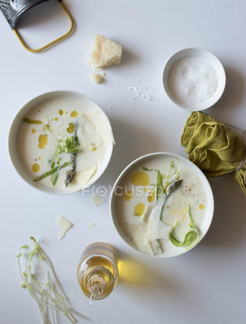 Schalen mit leckerer Spargelcremesuppe mit Käse und Kräutern auf weißem Hintergrund — Stockfoto