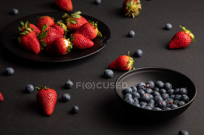 Различные свежие летние ягоды на черном фоне — стоковое фото