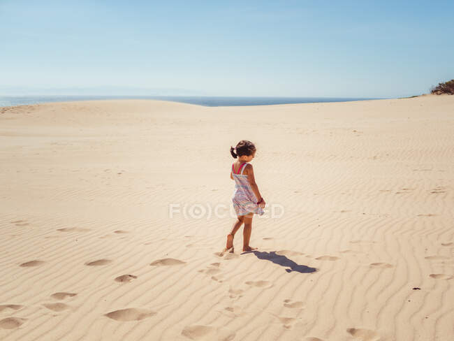 Cute little girl playing with sand at beach — Stock Photo